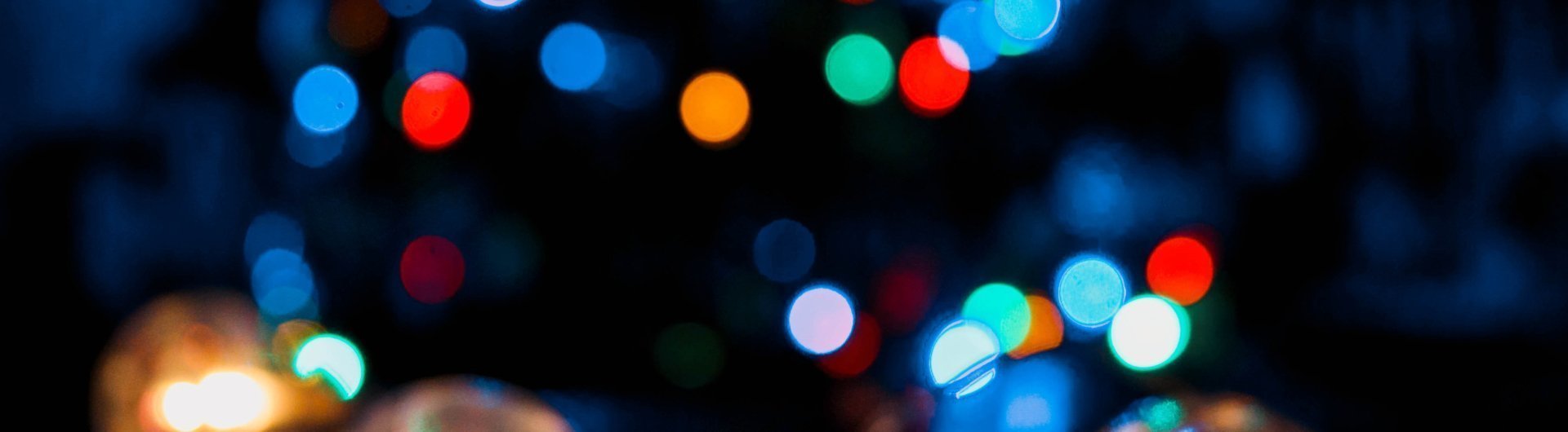 Een duidelijke kerstbal en wazige kerstballen met een kerstboom in de achtergrond